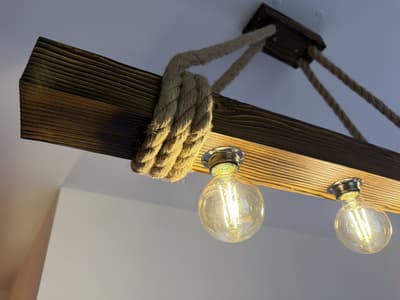 Lamp made of an old wooden beam hung on ropes